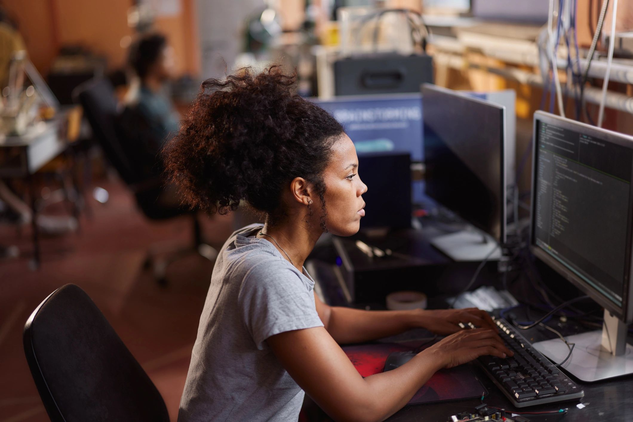 Woman coding at a computer in a lab setting