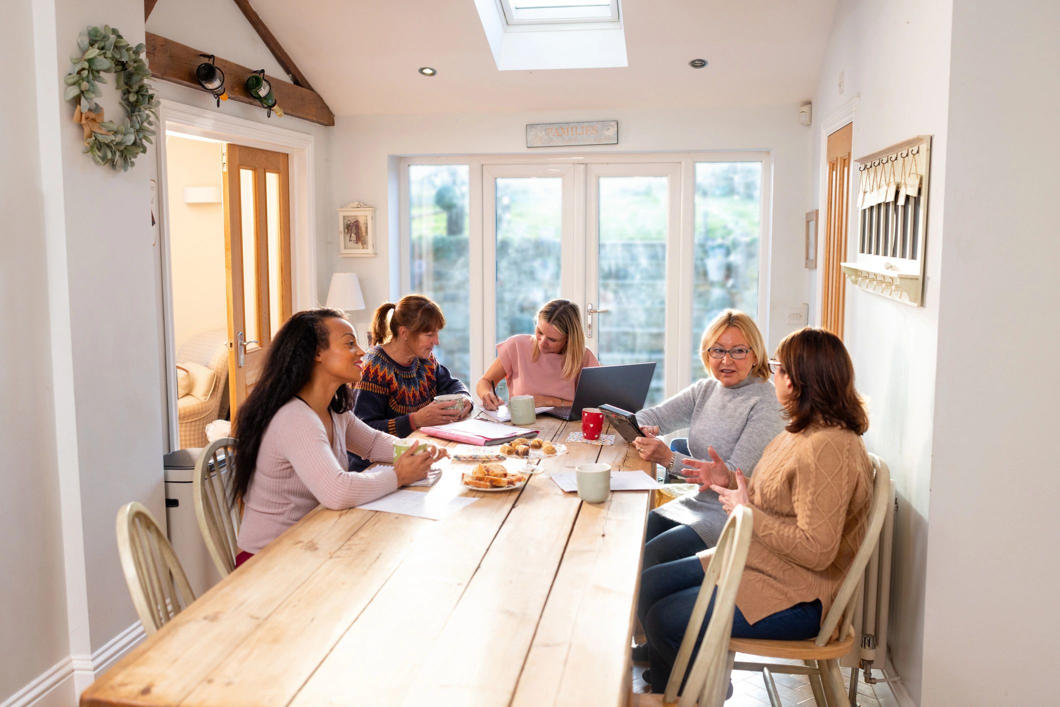 Women gathered at a community meeting taking notes and discussing